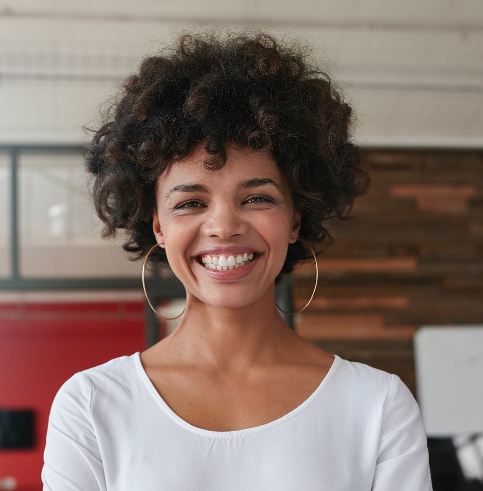 smiling-young-woman-standing-in-creative-office.jpg